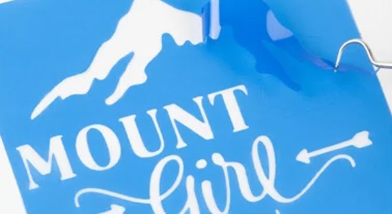 Primo piano dello stencil di una montagna innevata e della MOUNT Girl sottostante.